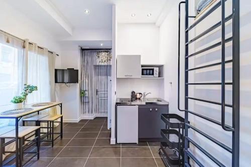 une cuisine et une salle à manger avec une table et des chaises dans l'établissement Studio cosy avec mezzanine, bien équipé, Caluire, à Caluire-et-Cuire