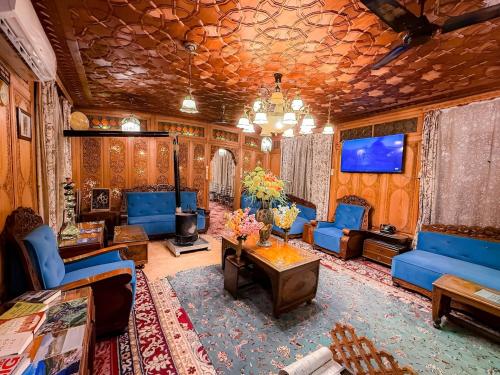 a living room with blue couches and a tv at Dilnaaz group of houseboats in Srinagar