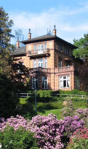 a large brick house with flowers in front of it at Ferienwohnungen Schwabenhof in Schramberg