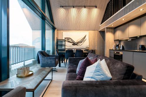 a living room with couches and a table at Attraktiv leilighet på kaikanten i Henningsvær in Henningsvær