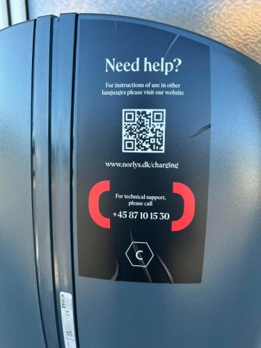 a need help sign on the side of a refrigerator at Hirtshals Idrætscenter - Vandrehjem - Hostel in Hirtshals