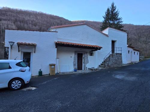 une maison blanche avec une voiture garée devant elle dans l'établissement La Genette, à Prats-de-Mollo-la-Preste