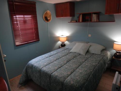 - une chambre avec un lit avec deux lampes et deux fenêtres dans l'établissement Mobil-Home de Jean-Michel et Nicole, à Hyères