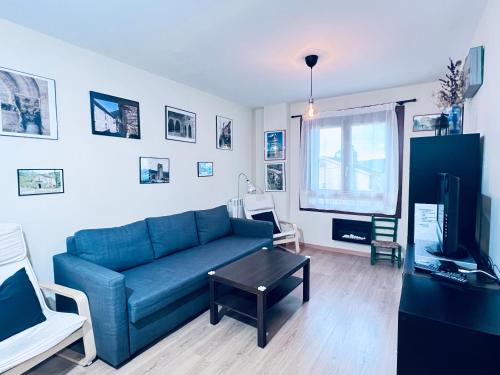 a living room with a blue couch and a tv at Apartamento Espata IX in Villanúa