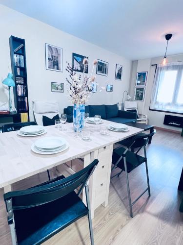 a dining room with a white table and chairs at Apartamento Espata IX in Villanúa