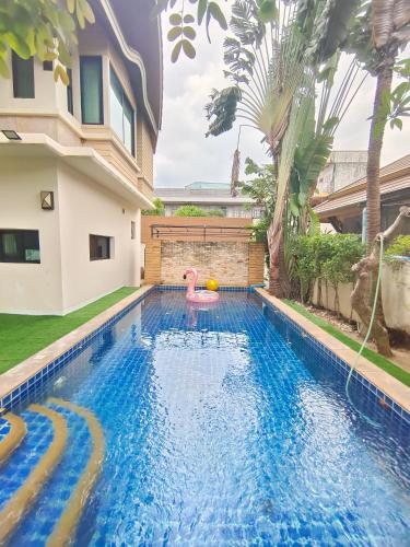 a pool with a pink flamingo in a house at Baan Natcha Pool Villa City Center in Pattaya