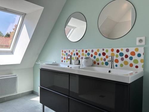 une salle de bain avec un lavabo et un miroir dans l'établissement Maison lumineuse, entièrement rénovée, à quelques pas de la plage et des commerces., à Erquy