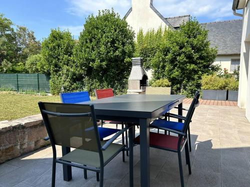une table noire et des chaises sur une terrasse dans l'établissement Maison lumineuse, entièrement rénovée, à quelques pas de la plage et des commerces., à Erquy