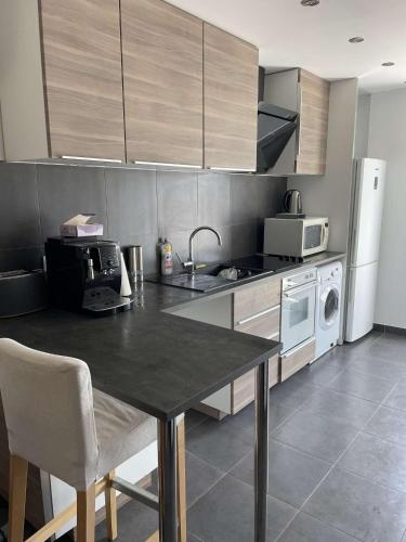 Il comprend une cuisine équipée d'une table, d'une cuisinière et d'un four micro-ondes. dans l'établissement Vacances à Sainte-Maxime, à Sainte-Maxime