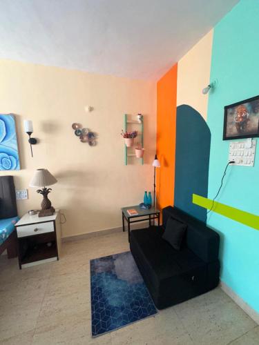 a living room with a couch and a bed at Neon Nirvana Deluxe Apartments in North Goa Near Calangute Candolim Anjuna in Nagoa-Bardez