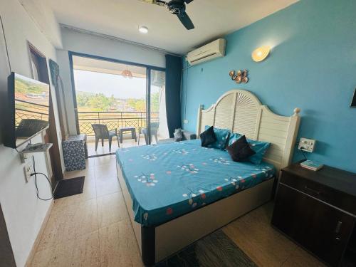 a bedroom with a bed and a balcony at Neon Nirvana Deluxe Apartments in North Goa Near Calangute Candolim Anjuna in Nagoa-Bardez