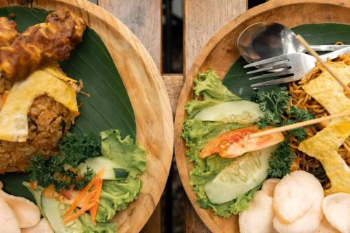 two plates of food with vegetables and meat on them at Bobocabin Gunung Rinjani, Lombok in Sembalun Lawang