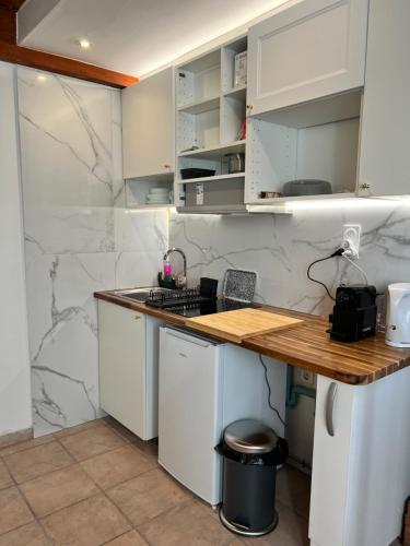 une cuisine avec des armoires blanches et un comptoir dans l'établissement Le Ramblas Jean Jaures Matabieu, à Toulouse