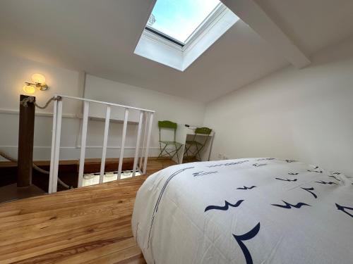 une chambre avec un lit et une lucarne dans l'établissement Le Ramblas Jean Jaures Matabieu, à Toulouse