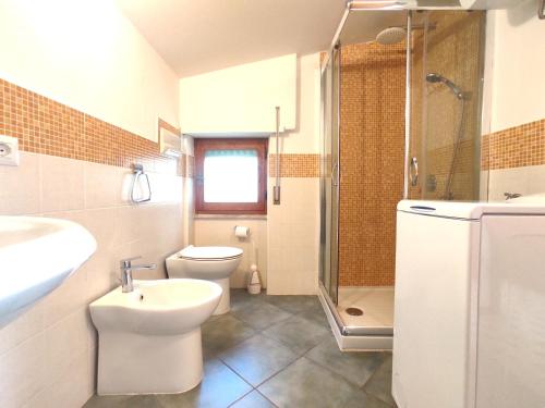 a bathroom with a toilet and a sink and a shower at Attico Orizzonte, splendida vista sul golfo IUN T2810 in Cala Gonone