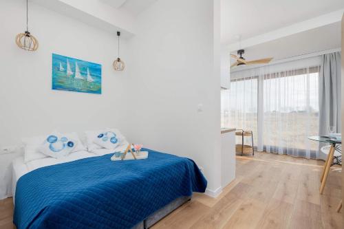 a bedroom with a blue bed with a blue blanket at Modern & Spacious Apartments Baltin Blu by Noclegi Renters in Sarbinowo