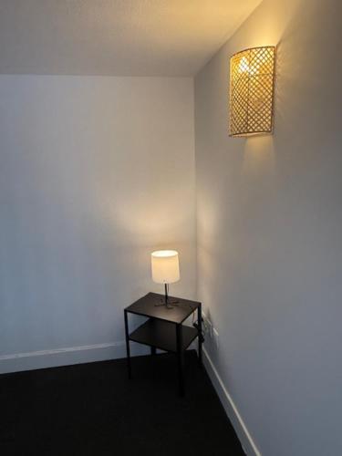 a small table with a lamp on a wall at OULLINS T3 COSY 70M2 - 6 Pers 2 Chambre - 2 Mezzanines Métro & centre à Pied in Oullins