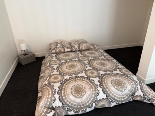 a bed in a bedroom with a blanket on it at OULLINS T3 COSY 70M2 - 6 Pers 2 Chambre - 2 Mezzanines Métro & centre à Pied in Oullins