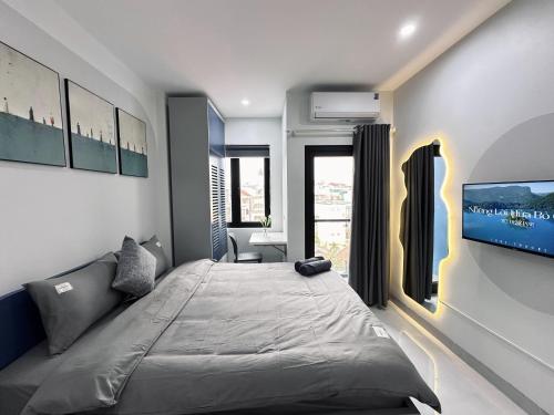 a bedroom with a bed and a flat screen tv at The Little Hanoi - Cool Apartment - Lakeside in Hanoi