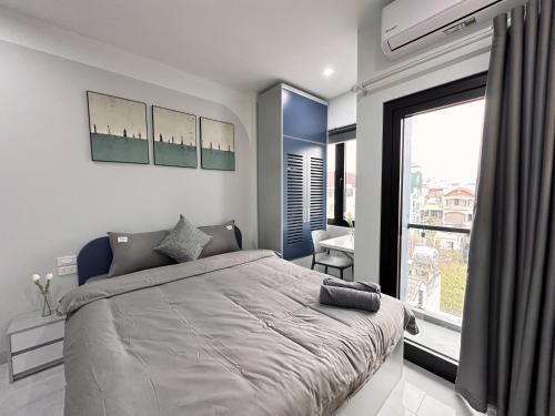 a bedroom with a large bed and a large window at The Little Hanoi - Cool Apartment - Lakeside in Hanoi