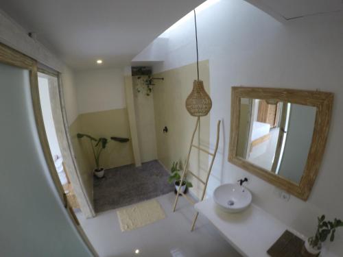 a bathroom with a sink and a mirror at Trika Surfcamp Bali in Airsatang