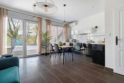 une cuisine et une salle à manger avec une table et des chaises dans l'établissement Charme de l'ancien, confort et terrasse, Caluire, à Caluire-et-Cuire