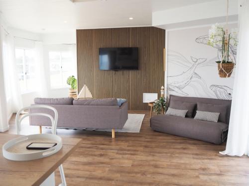 a living room with two couches and a tv at Tangalooma Life - 2 Bed 2 Bath Private Luxury Stay in Tangalooma