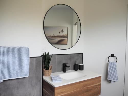 a bathroom with a sink and a mirror at Tangalooma Life - 2 Bed 2 Bath Private Luxury Stay in Tangalooma