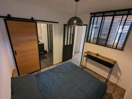 - une chambre avec un lit, une porte et une table dans l'établissement Petit corbin, à Vannes