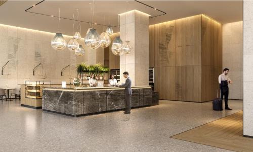 two people standing in a lobby with a bar at Hyatt Place Ha Long Bay, Bai Chay in Ha Long