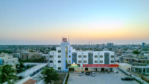 a building with a clock tower in a city at Daksh The Grand Goverdhan in Dwarka