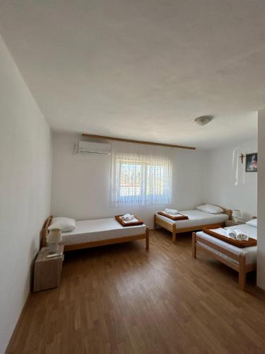 a room with two beds and a window at Rooms Vidović in Međugorje