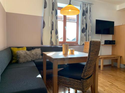 a living room with a table and a couch at Pension Kramerhof in Taufkirchen