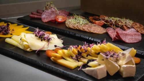 two trays with different types of cheese and meats at Hunguest Hotel Flóra in Eger
