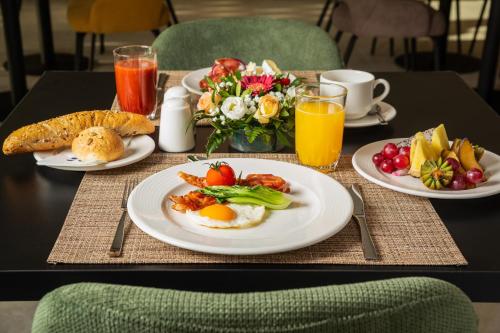 a table with plates of breakfast foods and drinks at Hunguest Hotel Flóra in Eger