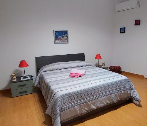 a bed in a bedroom with two lamps and a bed sidx sidx sidx at La Casa di Niña in Augusta