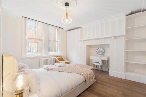 a white bedroom with a bed and a window at HAFH in Farringdon- Stylish 1Bedroom Apartments in London