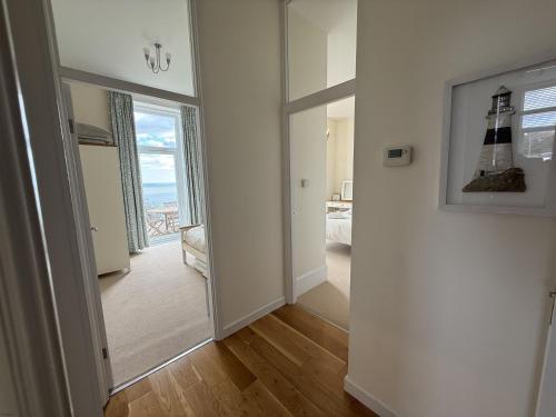 Habitación con pasillo con espejo y habitación con ventana en Ocean View, en Seaton