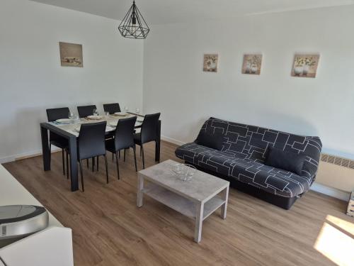 un salon avec un canapé, une table et des chaises dans l'établissement Appartement Chez A.S.Y., à Guérande