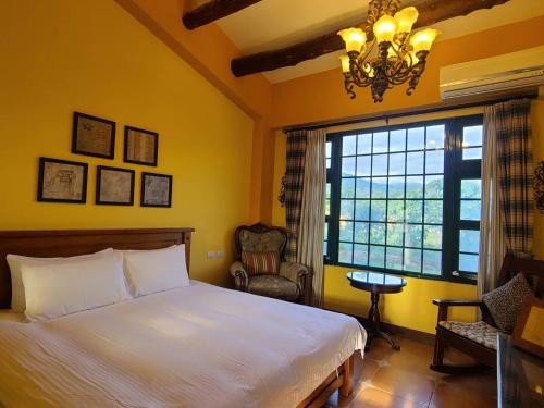 a bedroom with a bed and a window and a chandelier at 台東鹿野森活 訂房來電付訂確認 in Ruiyuan