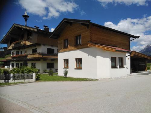 a house with a wooden roof on top of it at Ferienwohnungen Recherhof in Hochfilzen