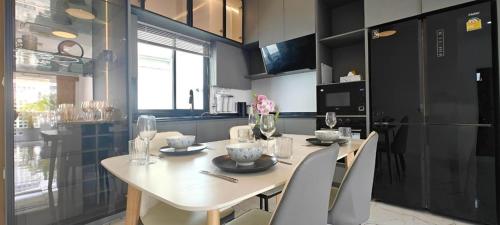 a kitchen with a white table and chairs and a refrigerator at Modern Villa with Big Jacuzzi Lets Relax at City LRP4 in Nong Prue