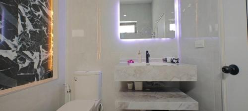 a bathroom with a sink and a toilet and a mirror at Modern Villa with Big Jacuzzi Lets Relax at City LRP4 in Nong Prue