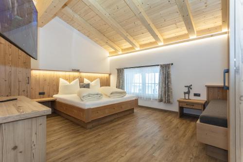 a large bedroom with a bed and a window at Ferienwohnungen Recherhof in Hochfilzen