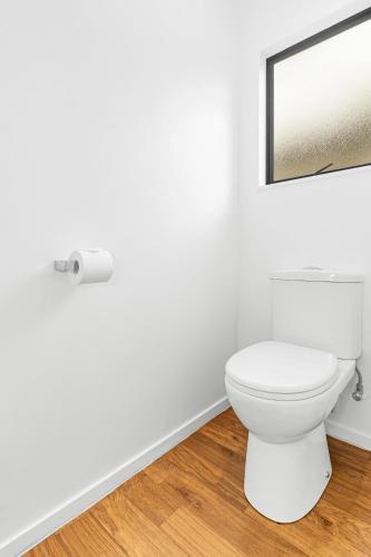 a bathroom with a white toilet and a mirror at Auckland Airport Motel in Auckland