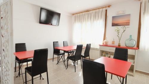 a dining room with red tables and black chairs at Hotel Paradís in Torredembarra