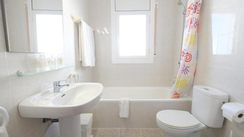 a bathroom with a sink and a toilet and a bath tub at Hotel Paradís in Torredembarra