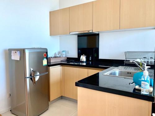 a kitchen with a stainless steel refrigerator and a sink at Wind Studio More than 3 nights stay in Bangkok