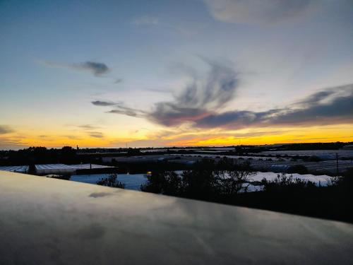 a sunset over a body of water with the sky at Mandulivi, chalet nel mandorleto e mansarda vista mare in Villaggio Azzurro