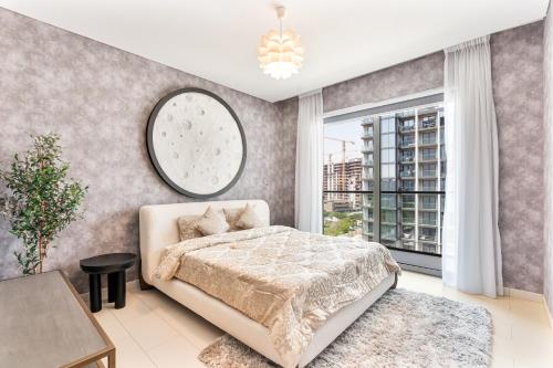 a bedroom with a bed and a large window at Luxury 2BR in Sobha Hartland in Dubai